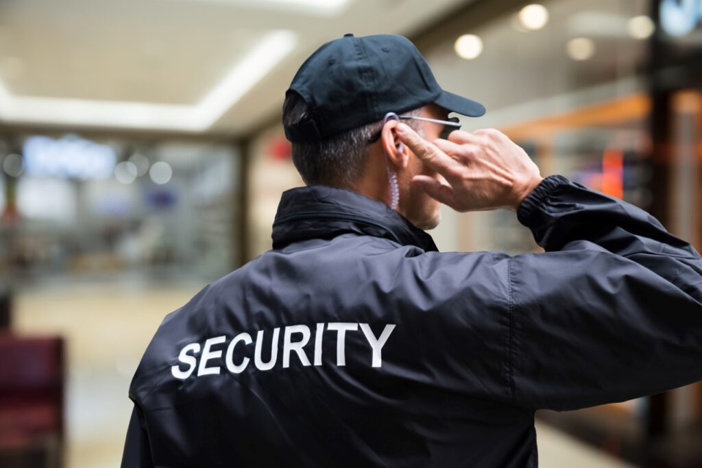 Rear view of mature security guard listening to earpiece